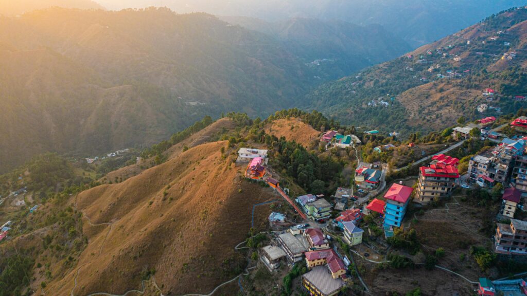 Scenic aerial view of Shimla's mountainous landscape illuminated by the warm sunrise.